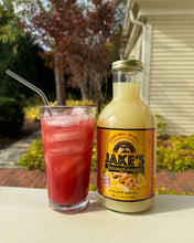 Load image into Gallery viewer, A ginger pomegranate mocktail next to a 32oz bottle of Jake's Organic StrongGinger Juice