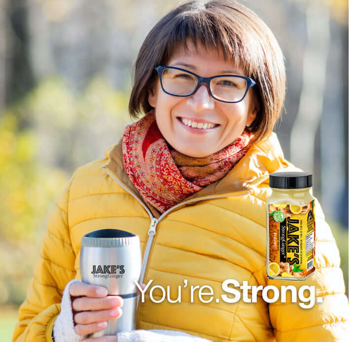 Woman in a yellow jacket drinking Jake's StrongGinger organic ginger juice in a thermal mug