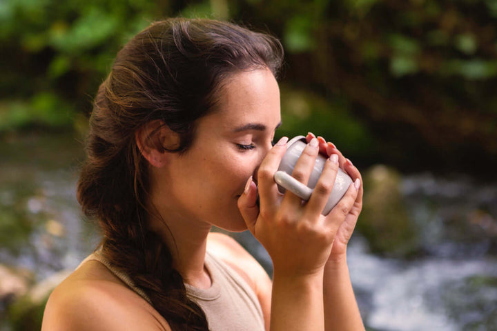 A woman drinking Jake's StrongGinger organic ginger juice to help with a cold