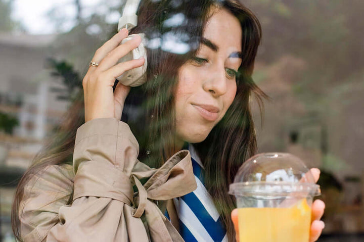 Jake's StrongGinger organic ginger juice being enjoyed by a woman in the outdoors.