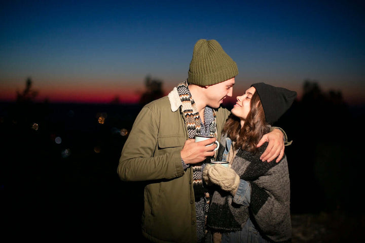 Couple next to campfire drinking Jake's StrongGinger organic ginger juice to depict its ability of boost sexual performance.