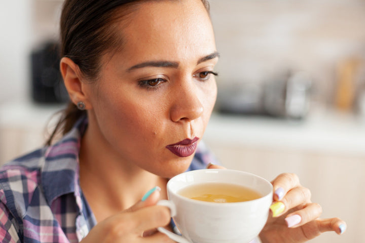 Woman drinking hot Jake's StrongGinger organic ginger juice