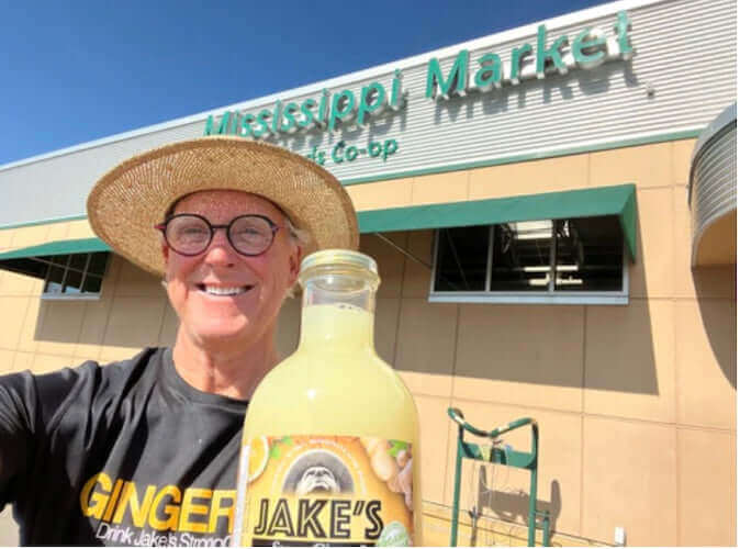 Jake with a bottle of Jake's StrongGinger organic ginger juice outside Mississippi Market in St. Paul, MN