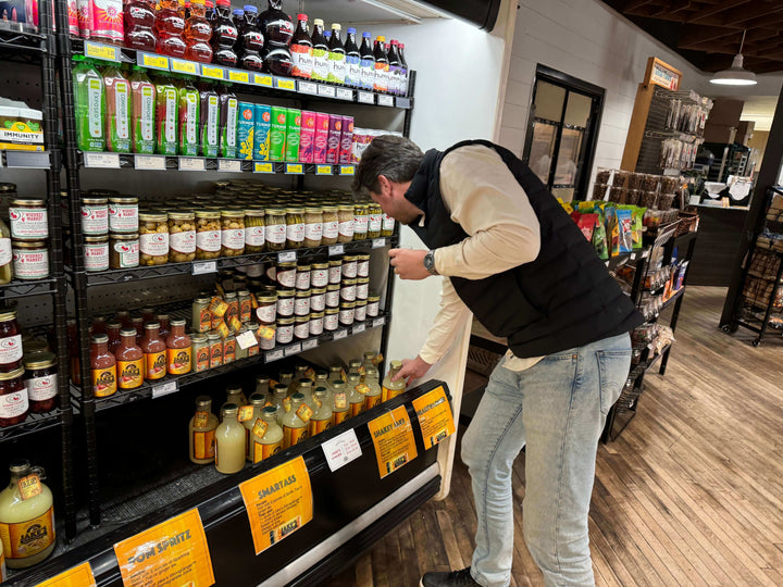 Shopper buying a bottle of Jake's StrongGinger organic ginger juice at Woodlake market in Kohler, WI
